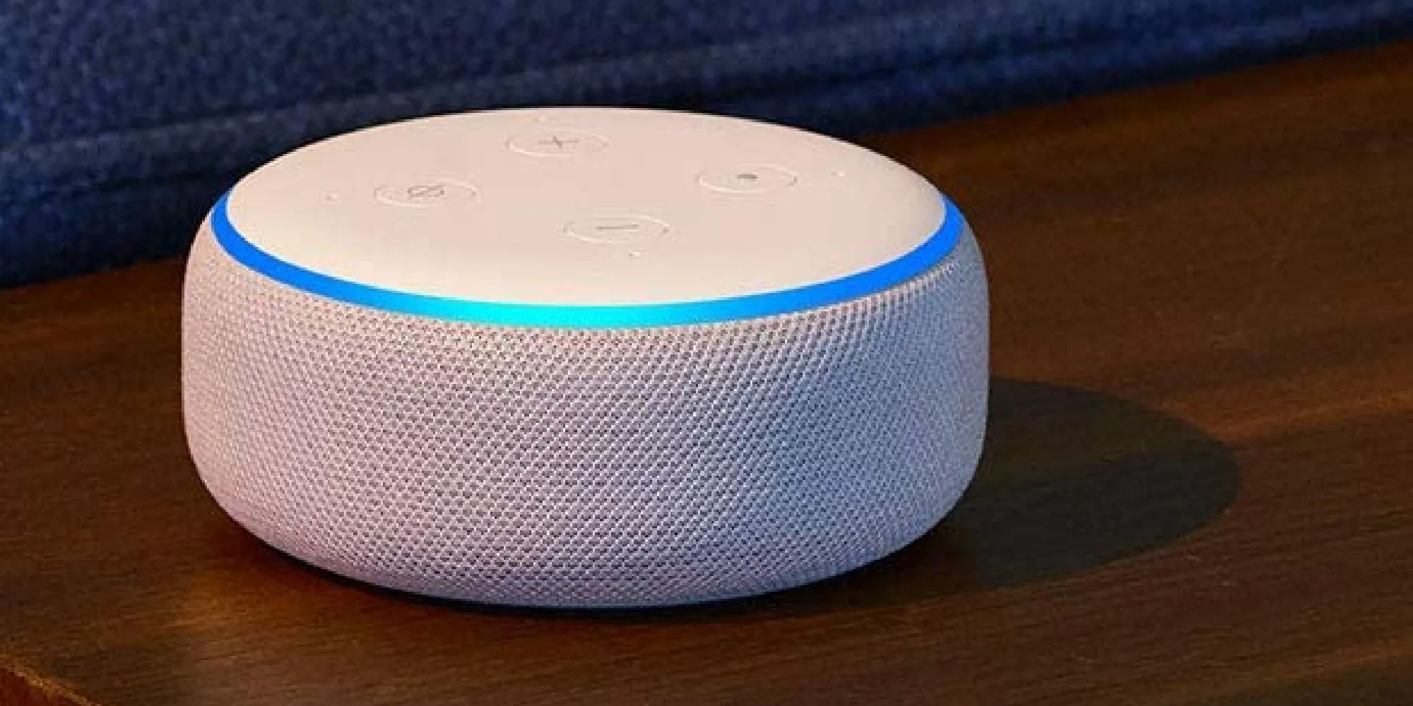 Thiết bị loa thông minh Amazon Alexa màu trắng trên mặt gỗ, minh họa ý tưởng Alexa gamer.
